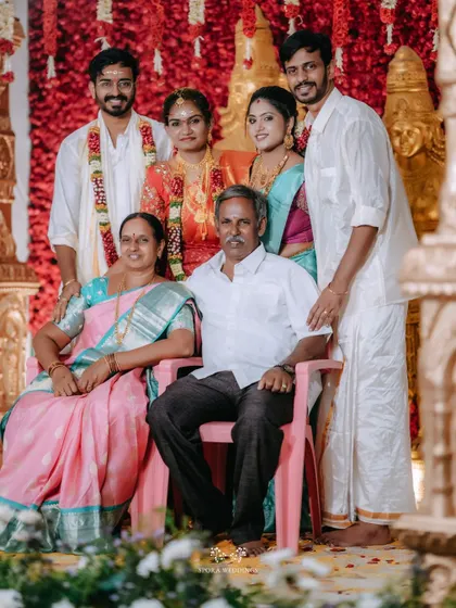 A beautiful family portrait, with the newly married couple posing with their parents and siblings.