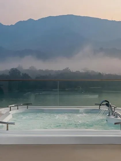 This outdoor jacuzzi at the Modi Yoga Retreat in Rishikesh offers a moment of pure bliss. Positioned to overlook the misty mountains and the Ganges, it provides an unparalleled experience of unwinding in the lap of nature.