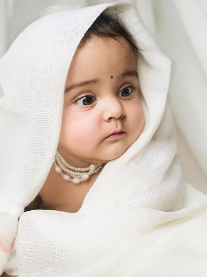 A duplicate of image 181, showing a baby's face peeking out from a white cloth, creating a soft and innocent portrait.