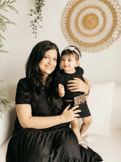 A sweet portrait of a mother and her little girl, both dressed in black for a classic, coordinated look.
