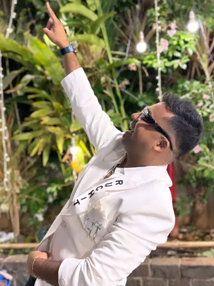 Pointing upwards, celebrating a successful event. The custom "RUCHIT" embroidery on my jacket is a signature touch.