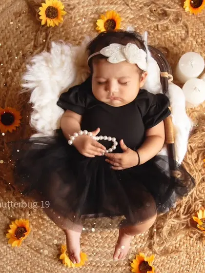 A beautiful overhead shot of a newborn surrounded by sunflowers, capturing the peace and innocence of a new life.