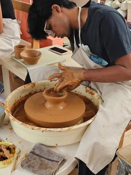 A student in a one-day workshop trying his hand at the potter's wheel. It's a great activity for anyone looking to explore their creative side.