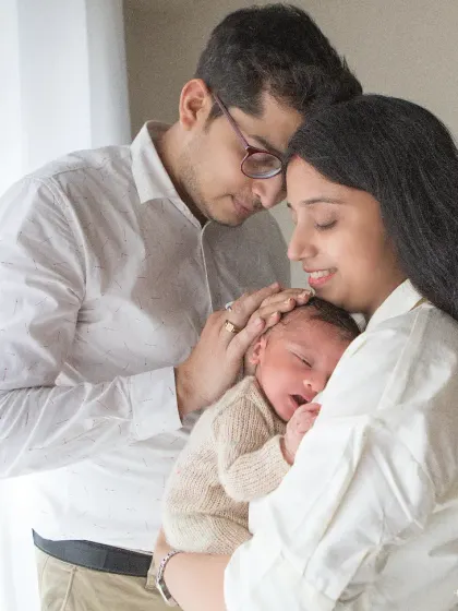 Soft light and softer emotions. This portrait captures the overwhelming love and gentleness as new parents admire their sleeping baby.