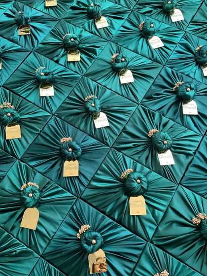 The visual impact of a bulk order is always stunning. Here is a sea of gifts, each meticulously wrapped in rich teal satin fabric with custom gold tags, ready to be dispatched for a large corporate event. This shows my capability to handle large volumes without compromising on aesthetics.