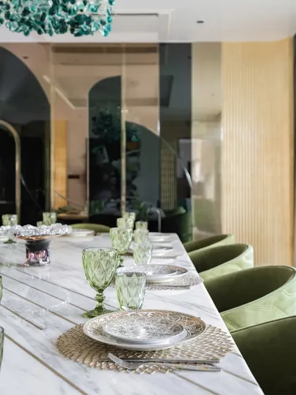 A view of one of our elegantly styled dining rooms. We focus on combining statement lighting, comfortable seating, and high-quality materials like marble and brass to create spaces that are perfect for both everyday meals and special occasions.