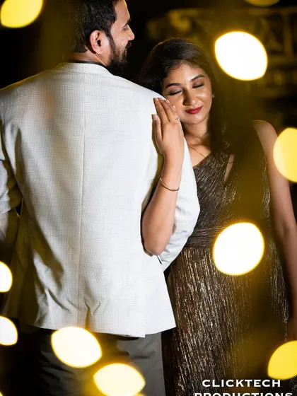 A tender moment with the bride resting her head on the groom's shoulder, softly lit and framed by the glow of fairy lights.