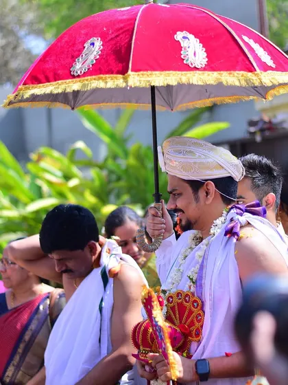 The groom's entry is just as important. Here, the groom arrives under a traditional umbrella (chattar), looking regal and ready for the wedding rituals.