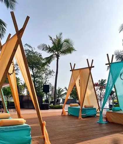 For a relaxed and modern vibe, I offer unique seating like these teepee-style cabanas. Shown here with turquoise and yellow fabrics, they are perfect for a daytime Mehendi or a poolside party.