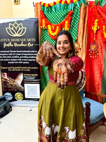 A happy guest showing off her beautiful Radha-Krishna themed mehendi.