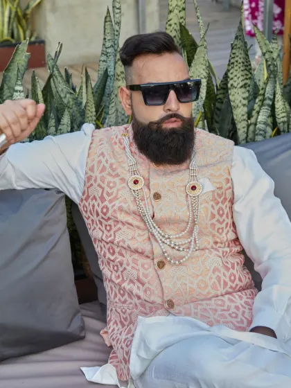 A relaxed yet regal pose in the light peach brocade waistcoat. The subtle details and luxurious fabric speak volumes, perfect for a wedding day.