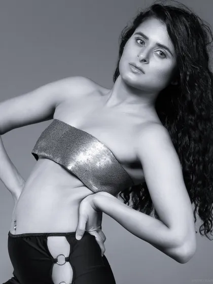 A black and white close-up, focusing on the model's expression and the texture of the top.