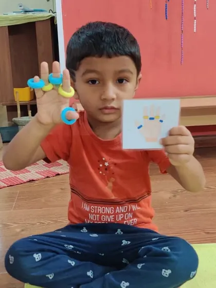 An exploratory activity where a child matches colored rings to a pattern card. This game enhances visual discrimination, pattern recognition, and fine motor skills.