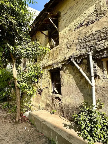 The side of a building at the Wada, showing the texture of the wall and the simple, functional form of a drainpipe. Even the most utilitarian elements contribute to the building's overall character.