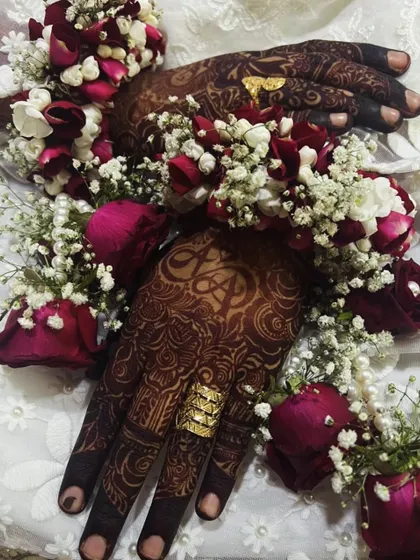 A gorgeous bridal shot where the custom initial 'A' is visible, perfectly accessorized with floral bracelets and gold rings.