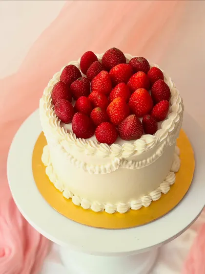 A classic and simple fresh fruit cake. The white buttercream is piped with a vintage-style border and filled with a mound of fresh, whole strawberries.