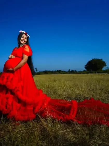 The long trail of this red ruffle gown creates a stunning visual, making it a fantastic choice for a dramatic maternity photoshoot.