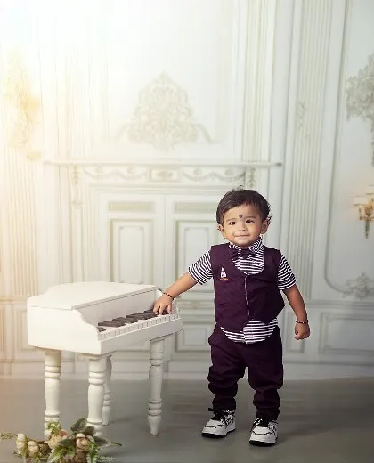 Standing with support and a charming smile. Sitter sessions are also great for capturing those exciting pre-walking moments, like this little one pulling himself up on the piano.