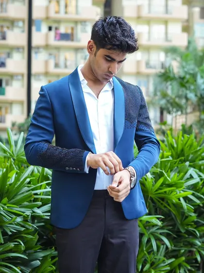 A model wearing a royal blue blazer with black embroidered sleeves. This is a great standalone piece to style for a party.