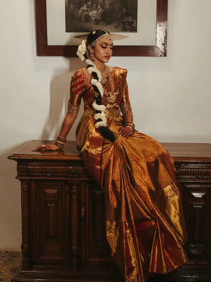 A close-up of the bride's attire, showcasing the rich texture of the Kanjivaram silk saree and the intricate details of her jewelry. These are the elements that tell a story of heritage.