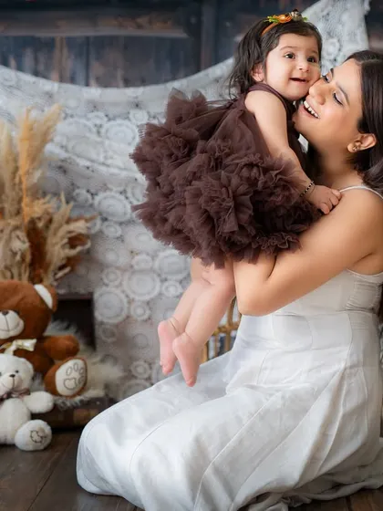 A mother lifts her daughter for a happy, playful moment. These candid interactions create the most authentic and joyful family photos.