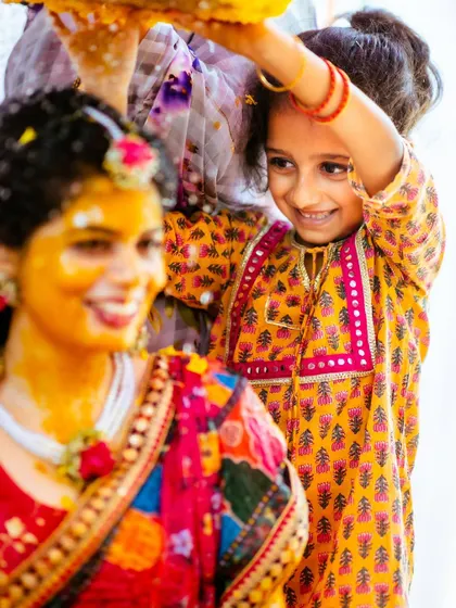 A close-up on the adorable interaction between the bride and the little girl during the Haldi rituals.