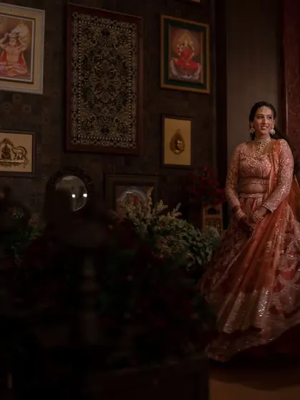 A bride twirling in her beautiful lehenga. This shot captures the movement and joy of the moment, set against a richly decorated, traditional backdrop.