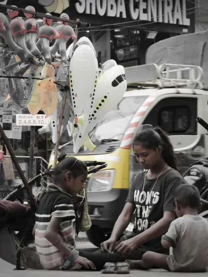 A different perspective on street vendors, focusing on the children who are often part of this life. The selective color highlights the yellow truck, adding a point of interest to the scene.