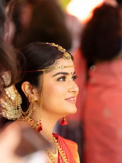 A side profile showing the traditional head jewelry and the elegant updo. Every detail is carefully planned.