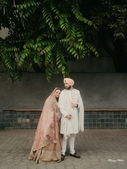 A quiet moment of togetherness. For this Anand Karaj ceremony, we chose a soft, layered pastel lehenga for the bride and a classic, understated sherwani for the groom, creating a look of serene, modern grace.