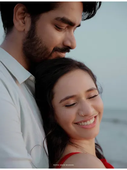 A quiet moment of peace and affection as the sun sets over the ocean. This is the serene side of a beach pre-wedding story.