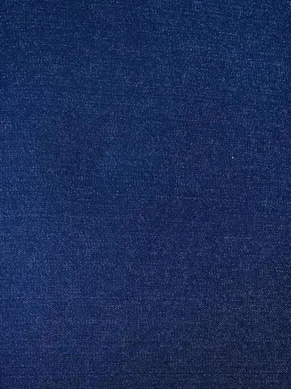 A deep indigo denim swatch. This is the foundation for classic raw denim jeans that will fade and develop character uniquely to you as you wear them.