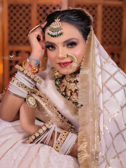 A charming seated portrait where the bride is looking up with a gentle smile. The pose is relaxed and happy, capturing a moment of pure joy.