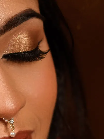 Another angle of the golden eye makeup, showing the sharp winged liner and full lashes that complete the look. This is a popular choice for muhurtham and reception events.