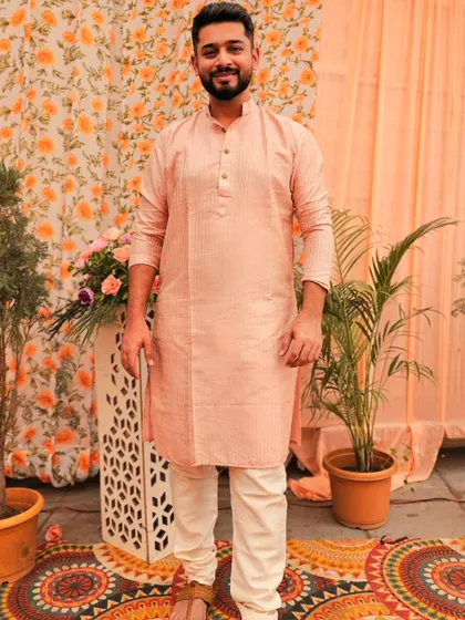 A full-length shot in a peach-colored kurta set against a festive backdrop. This is a perfect example of my work for wedding or celebration-themed apparel campaigns.