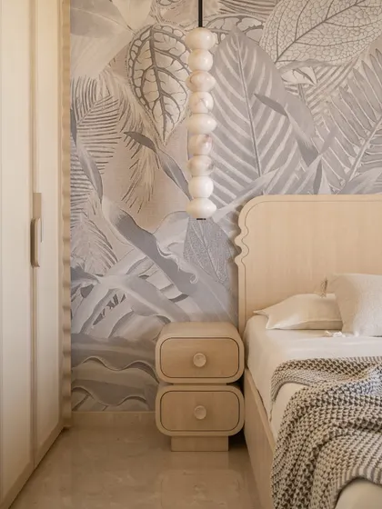 A detail of the guest bedroom, showing the custom alabaster pendant light and the texture of the wallpaper, which add an artisanal warmth to the minimalist space.