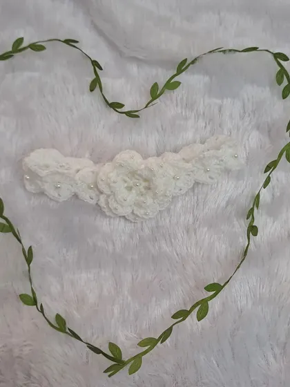 A simple and beautiful crochet headband. The white floral design is timeless, and the piece is framed by a heart-shaped vine to show it's made with love.