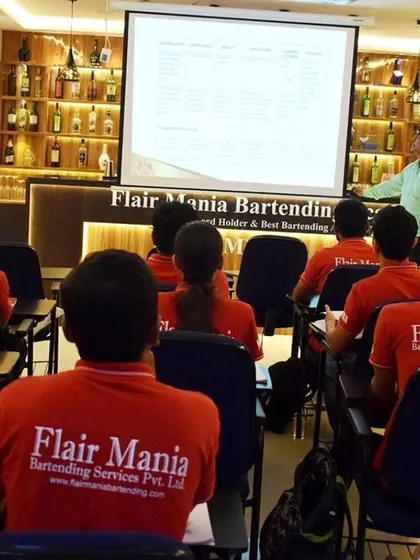 Students in their red Flair Mania uniforms attentively listening during a theory class.