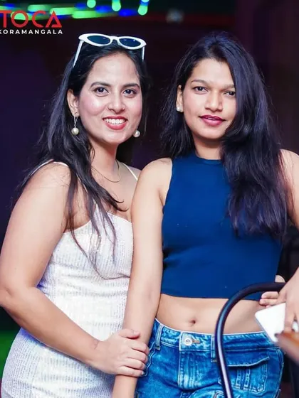 A stylish duo enjoying the vibrant atmosphere at Toca.