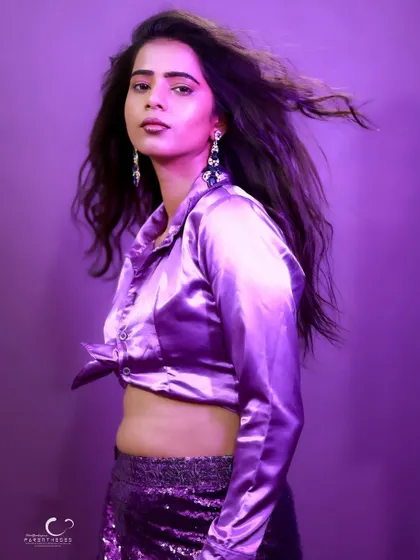 A chic and modern portrait in a purple satin outfit. The wind-blown hair adds a touch of effortless glamour.