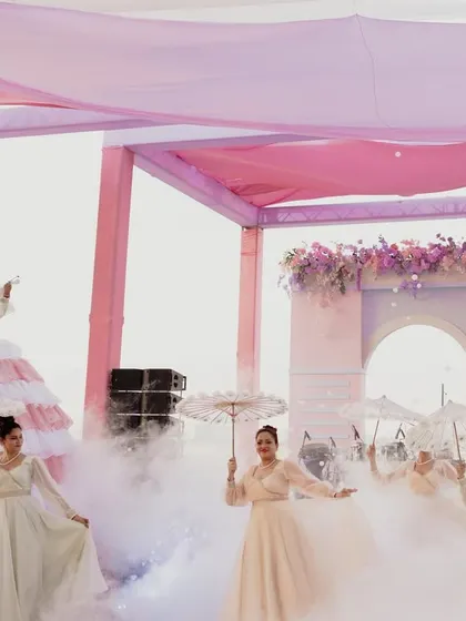 Dancers with parasols move through a cloud of smoke, creating a dreamy and dramatic performance to welcome guests to the Mehendi soirée.