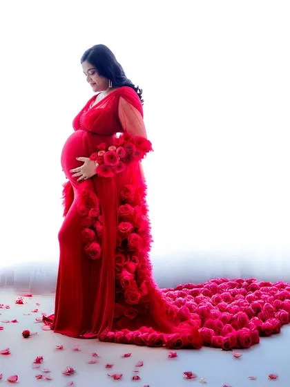 A high-impact portrait featuring a vibrant red gown with a train of roses. The high-key lighting makes the color pop, creating a truly memorable image.