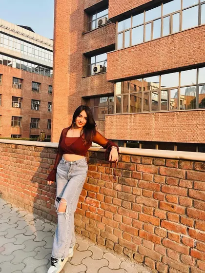 A golden hour shot in a sheer brown top and ripped jeans. This outfit is all about that relaxed, cool-girl vibe.