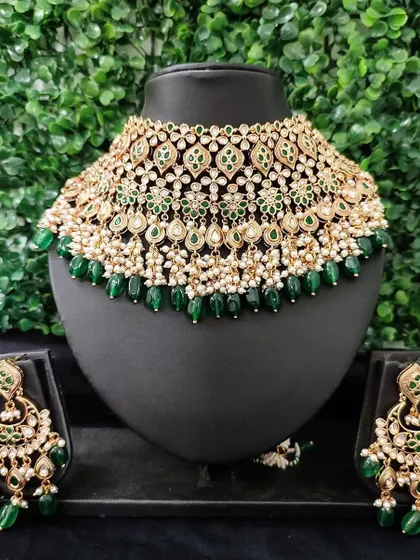 A beautiful green and white kundan choker set for rent. The design features delicate floral motifs and pearl drops, paired with matching earrings.