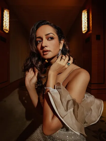 A close-up portrait of Shanvi, highlighting the delicate ruffled sleeve detail and the elegant jewelry pairing.