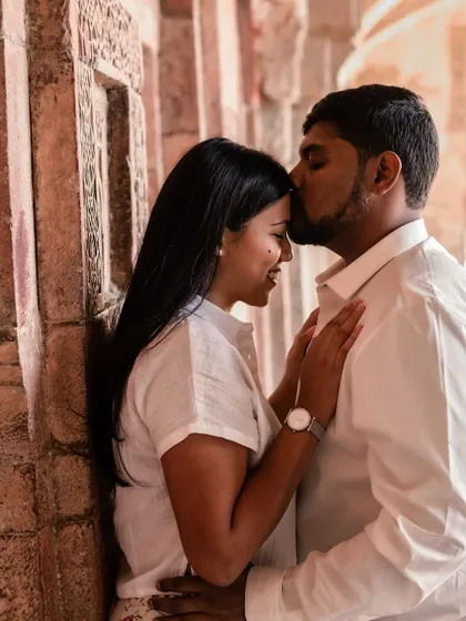 A tender forehead kiss, capturing a moment of pure affection and intimacy during a pre-wedding shoot at a Delhi park.