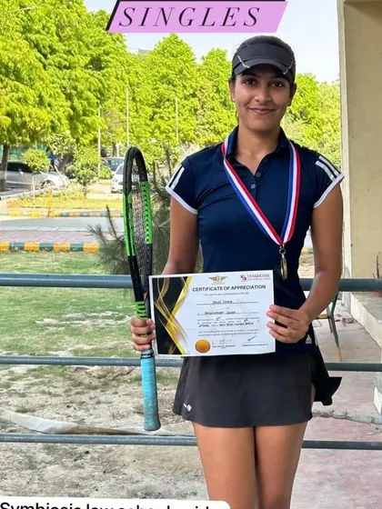 One of my players proudly displaying her medal and certificate after a win in the singles category. We celebrate every achievement, big or small.