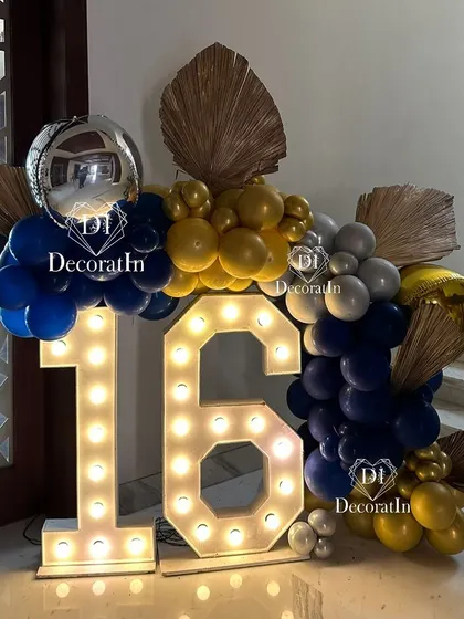 A large marquee '16' creates a bold statement piece, surrounded by a modern balloon arrangement.