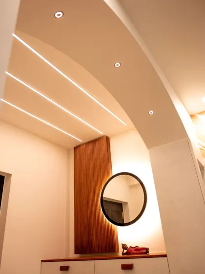An entryway featuring an arched ceiling with recessed profile lights and spotlights, creating a grand and welcoming entrance.