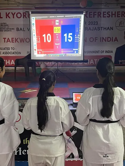 Participants at the seminar learning about the electronic scoring system used in modern Taekwondo competitions.